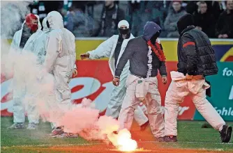  ?? FOTO: IMAGO ?? Szenen, die die Fußball-Welt nicht braucht: Kölner Chaoten stürmen nach der 0:1-Niederlage im Spiel bei Borussia Mönchengla­dbach den Platz und zünden Bengalos.