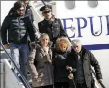  ?? GIUSEPPE LAMI/ANSA VIA AP ?? Gaetano Di Agostino, bottom right, father of Italian victim Fabrizia Di Lorenzo, holds a rose as he is followed by his wife Giovanna, center, and his son Gerardo, top left,, while disembarki­ng a plane carrying the coffin of their daughter from Berlin...