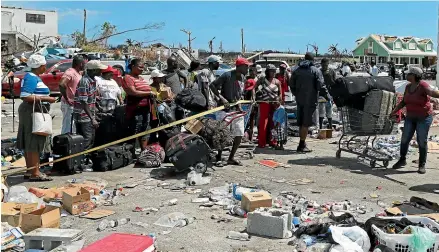  ?? AP ?? People line up to be evacuated to Nassau in the aftermath of Hurricane Dorian, from the port of Marsh Harbor, Abaco Island, Bahamas.