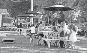  ?? RICK WOOD/MILWAUKEE JOURNAL SENTINEL ?? Patrons of Triciclo Peru, 3801 W. Vliet St., take their meals to distanced picnic tables across the street from the restaurant. The seating area is behind a new produce stand.