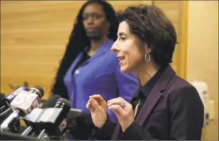  ?? Steven Senne / Associated Press ?? Rhode Island Gov. Gina Raimondo, right, and R.I. Director of Health Nicole Alexander-Scott, behind, face reporters during a news conference Sunday in Providence, R.I.