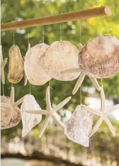  ??  ?? |ABOVE LEFT| SEASHELL. Natural textures and materials are a big part of adorning a porch. Here a shell-and-sea star windchime brings a lively touch to the outdoor sanctuary.