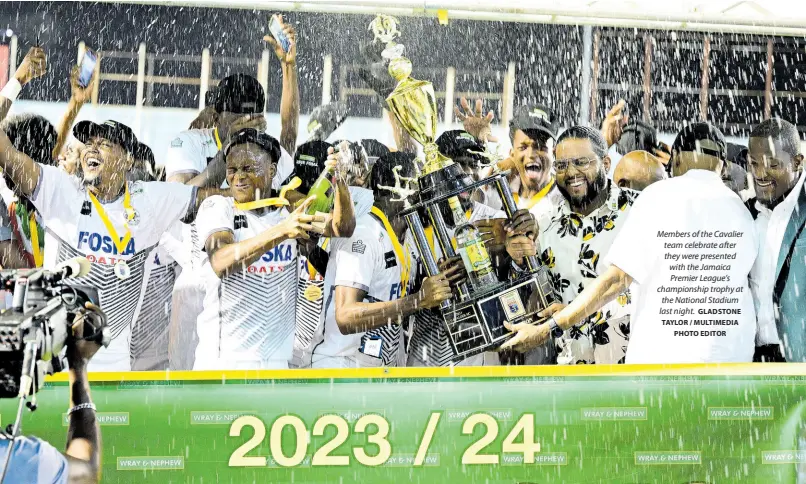  ?? GLADSTONE TAYLOR / MULTIMEDIA PHOTO EDITOR ?? Members of the Cavalier team celebrate after they were presented with the Jamaica Premier League’s championsh­ip trophy at the National Stadium last night.