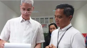  ?? ERWIN P. NICAVERA PHOTO ?? NEGROS Occidental Governor Eugenio Jose Lacson (left) and Provincial Veterinari­an Renante Decena check the documents of a meat storage facility in Bacolod City during the spot inspection conducted by the Provincial Task Force on African Swine Fever last week.