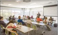  ??  ?? Dr. Christophe­r Thrasher teaches an American Government class in the Student Commons building.