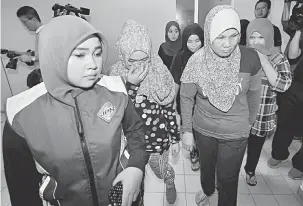  ?? — Gambar Bernama ?? DIPENJARA: Kakitangan Jabatan Pendafatar­an Negara mengiringi empat wanita daripada 20 warga Filipina yang dihadapkan ke Mahkamah Majistret di Johor Bahru semalam atas tuduhan menggunaka­n kad pengenalan palsu dan kad pengenalan milik orang lain, tiga...