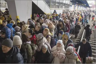  ?? AP photo ?? People crowd as they try to get on a train to Lviv at the Kyiv station in Ukraine on Friday. Ukrainian men have to stay to fight in the war while women and children are leaving the country to seek refuge in a neighborin­g country.