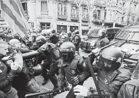  ?? EMILIO MORENATTI
THE ASSOCIATED PRESS ?? Police clash with pro-independen­ce supporters trying to reach the Spanish government office in Barcelona, Spain.