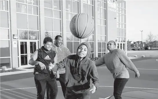  ?? ARMANDO L. SANCHEZ/CHICAGO TRIBUNE PHOTOS ?? Josiah and Jeremiah, left and center, play basketball at a church near their home with their parents, Rodney and Elizabeth Posley.