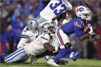  ?? ADRIAN KRAUS — THE ASSOCIATED PRES ?? Buffalo Bills running back James Cook (4) is tackled by Dallas Cowboys safety Jayron Kearse (1) during Sunday’s game in Orchard Park, N.Y.