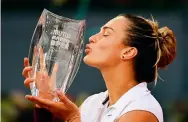  ?? Photo: AFP ?? Aryna Sabalenka kisses her trophy at the Madrid Open.