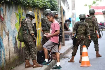  ??  ?? Members of the Brazil Armed Forces ask a resident for his identifica­tion, during an operation inside the favelas of Chapeu-Mangueira and Babilonia at Leme neighbourh­ood, in Rio de Janeiro, Brazil. — AFP photo