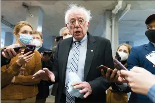  ?? AP PHOTO/JACQUELYN MARTIN, FILE ?? FILE - Sen. Bernie Sanders, I-Vt., makes comments to reporters about Sen. Joe Manchin, D-W.Va., as he walks to the Senate Chamber for a vote, on Dec. 15, 2021, in Washington. Just over a year ago, millions of energized young people, women, voters of color and independen­ts joined forces to send Joe Biden to the White House. But 12 months after he entered the Oval Office, many describe a coalition in crisis.