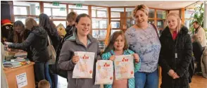  ??  ?? Annika, Jasmin, Mama Evelin und Sophie Nehm (von links) haben so viele Bücher gekauft, dass der Henkel der Tasche gerissen ist.