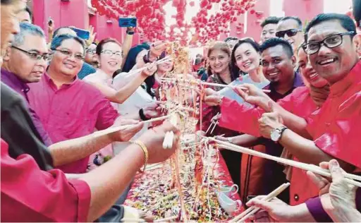  ?? PIC BY NOOR HIDAYAH TANZIZI ?? Perak Menteri Besar Datuk Seri Ahmad Faizal Azumu (right) and guests tossing yee sang on a 60m-long table, believed to be the longest yee sang dish in Perak, in conjunctio­n with Chinese New Year in Marina Island, Lumut, on Saturday.