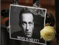  ?? (AP/Kirsty Wiggleswor­th) ?? A flower and a picture are left as a tribute to Russian politician Alexei Navalny on Feb. 18, near the Russian Embassy in London.