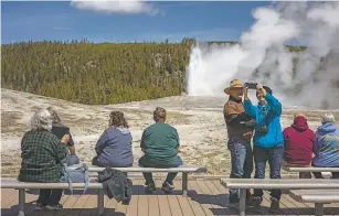  ?? KAYLA RENIE/ASSOCIATED PRESS ?? Tourists in April watch Old Faithful erupt in Yellowston­e National Park in Wyoming. During Yellowston­e’s offseason, visitors can take advantage of the less crowded conditions.