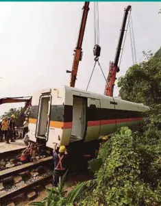  ??  ?? Rescuers removing parts of the train which derailed in a tunnel north of Hualien County, eastern Taiwan, yesterday.