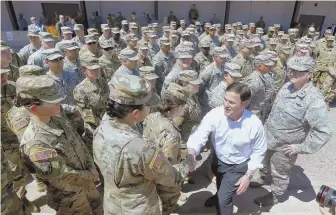 ?? AP PHOTOS ?? PATROL: Arizona Gov. Doug Ducey, above, meets with Arizona National Guard soldiers prior to their deployment yesterday. At left, soldiers review their paperwork.