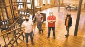  ?? AMY DAVIS/BALTIMORE SUN ?? Developer Stefan Popescu, from left, is joined by Martin Coad, director of operations and brew master, Des Comer, manager, and Kathleen Lechleiter, president of Twopoint architectu­ral studio, in the tasting room of the new Guilford Hall Brewery in the old Crown Cork and Seal garage and horse stables on Guilford Avenue.