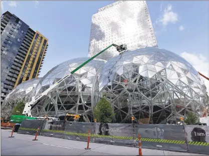  ?? ELAINE THOMPSON — ASSOCIATED PRESS ?? Constructi­on continues on three large, glass-covered domes as part of an expansion of the Amazon.com campus in downtown Seattle. Amazon said it will spend more than $5 billion to build another headquarte­rs in North America to house as many as 50,000...