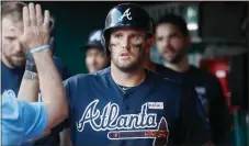  ??  ?? John Minchillo / The Associated Press
Atlanta’s Matt Adams celebrates in the dugout after hitting a go-ahead solo home run in the 12th inning of Saturday’s game in Cincinnati.