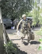  ?? EVGENIY MALOLETKA AP ?? A Ukrainian serviceman carries his gear during rotation at the frontline in Kharkiv region, Ukraine, on Saturday.