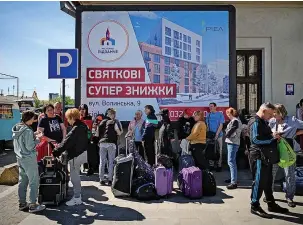  ?? LEON NEAL ?? Refugees in Lviv wait for humanitari­an coaches at a transport hub