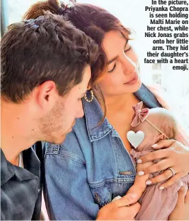  ?? ?? In the picture, Priyanka Chopra is seen holding
Malti Marie on her chest, while Nick Jonas grabs
onto her little arm. They hid their daughter’s face with a heart
emoji.