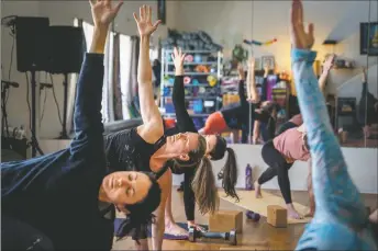  ?? NATHAN BURTON/Taos News ?? Yoga practition­ers fill High Frequency Loft on Friday morning (Feb. 25) for a yoga sculpt class taught by Hollie Salazar.