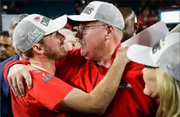  ?? Associated Press photos ?? Chiefs coach Andy Reid hugs son Britt, now a linebacker­s coach on his staff in Kansas City, as wife Tammy looks on Sunday after the Chiefs won the Super Bowl. The hugs were markedly different, below, as Andy hugged sons Spencer and Britt Aug. 7, 2012, after a memorial service for Garrett, who died of a heroin overdose,