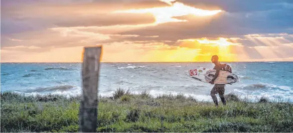  ?? FOTOS: DPA ?? Ab in die Wellen: Da auf Fehmarn fast immer Wind weht, ist die Insel bei Surfern beliebt, auch im Winter.