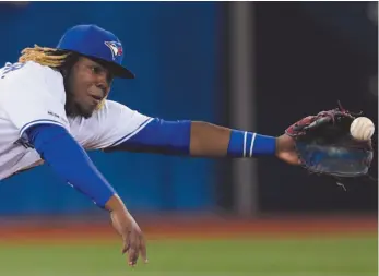  ?? CP PHOTO ?? Toronto Blue Jays third baseman Vladimir Guerrero Jr. (27) dives for single from Oakland Athletics center fielder Ramon Laureano during the eighth inning at a game in Toronto on Friday.