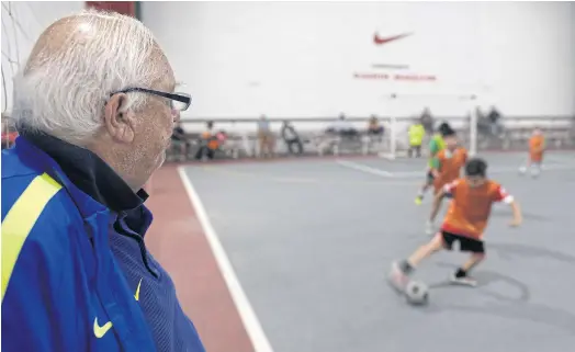  ??  ?? KEEPING A CLOSE EYE: Argentinia­n football talent scout Ramon Maddoni watches boys playing indoor football at Club Parque in Buenos Aires.