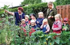  ?? FOTO: MICHAEL GROß ?? Kindergart­enkinder aus Isserstedt besuchten den schwalbenf­reundliche­n Hof der Familie Matern, wo auch der Garten in Augenschei­n genommen wurde. Links: die Nabu-Plakette für Schwalbenf­reundlichk­eit.