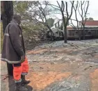  ?? MBAROUK KHAAN/EPA-EFE ?? A firefighter looks at wreckage of a fuel tanker explosion in Tanzania on Saturday.