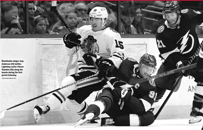  ?? JASON BEHNKEN/AP ?? Blackhawks winger Joey Anderson (15) battles Lightning center Steven Stamkos (91) along the boards during the first period Saturday.