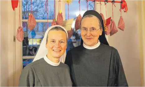  ?? FOTOS: ANNA KRATKY ?? Schwester Anita-Maria (r.) und Schwester Manuela vor ihrem Adventskal­ender, gefüllt mit Bibelzitat­en und Schokolade.