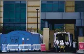  ?? ASHLEY LANDIS — THE ASSOCIATED PRESS FILE ?? Medical workers remove a stretcher from an ambulance near medical tents outside the emergency room at UCI Medical Center, in Irvine on Dec. 17.