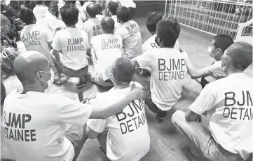  ??  ?? Detainees sit on the ground during a roll call after attending a court hearing at a Regional Trial court in Quezon City, Metro Manila, Philippine­s. — Reuters photo