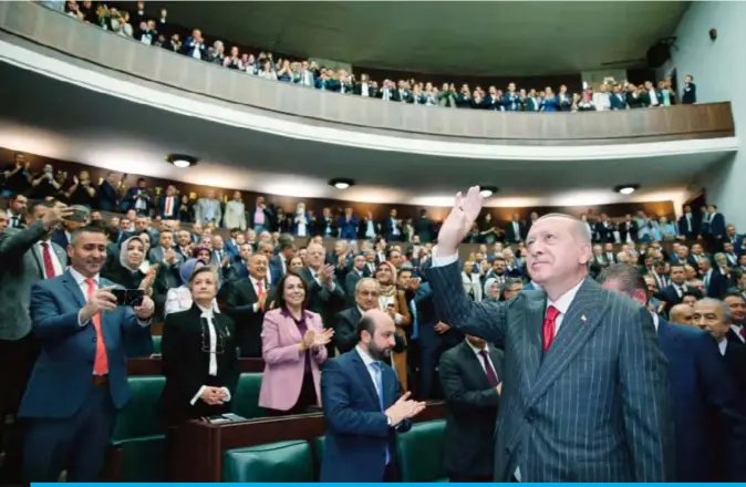  ??  ?? ANKARA: This handout picture taken yesterday shows Turkish President Recep Tayyip Erdogan gesturing in front of members of ruling Justice and Developmen­t Party (AKP) at their group meeting at the parliament. — AFP