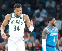  ?? ?? Milwaukee Bucks forward Giannis Antetokoun­mpo (34) points to a teammate Thursday after being fouled as Charlotte Hornets forward Miles Bridges (0) looks on during the first half of an NBA basketball game in Charlotte, N.C. (AP photo/nell Redmond)