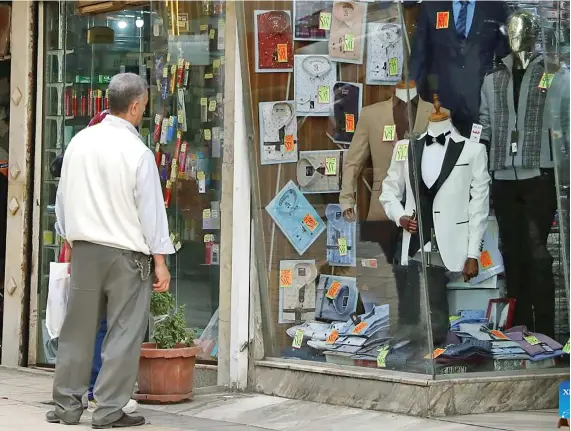  ?? ?? A man stands in front of a clothing store in Cairo, Egypt, on December 25, 2022.