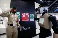  ?? — Photo by Leslie Pableo ?? A police officer interacts with a robocop at the Intersec exhibition in Dubai on Sunday.