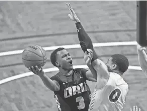  ?? JOSH JURGENS/AP ?? Oral Roberts guard Max Abmas (3) goes up for a layup against North Dakota State defender Dezmond Mckinney (0) at the Summit League men’s tournament championsh­ip March 9 in Sioux Falls, S.D.