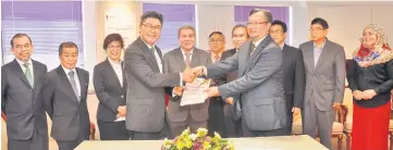  ??  ?? Sudarsono (left) hands over his duties to Wan Lizosman (right) witnessed by Awang Tengah (centre), Len Talif (back row, sixth left), Naroden (backrow, second left) and other officers.