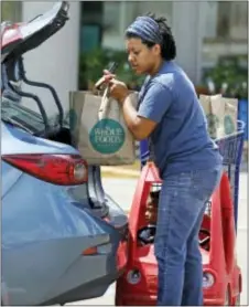  ?? ROGELIO V. SOLIS — THE ASSOCIATED PRESS ?? Whole Foods customer Bethany Capels, 34, of Mendenhall, Miss., loads her Whole Foods Market purchases in her car in Jackson, Miss., Friday. Amazon is buying Whole Foods Market in a deal valued at $13.7 billion, uniting the on-line giant with the...
