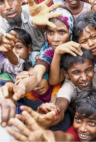  ?? — AFP ?? Nowhere to go: Rohingya refugees from Rakhine state waiting for aid at Kutupalong refugee camp in the Bangladesh­i town of Teknaf.