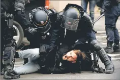 ??  ?? French CRS riot police apprehend a man in a street near Saint Lazare train station during a national day of protest in Paris. — Reuters photo