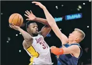  ?? Harry How Getty Images ?? JULIUS RANDLE, shooting against Kristaps Porzingis, finished with 27 points against New York on Sunday.